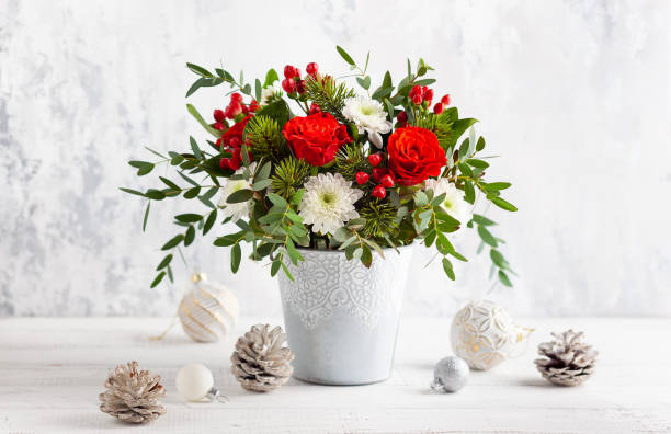 Bold red and white floral arrangement with greenery in a ceramic container