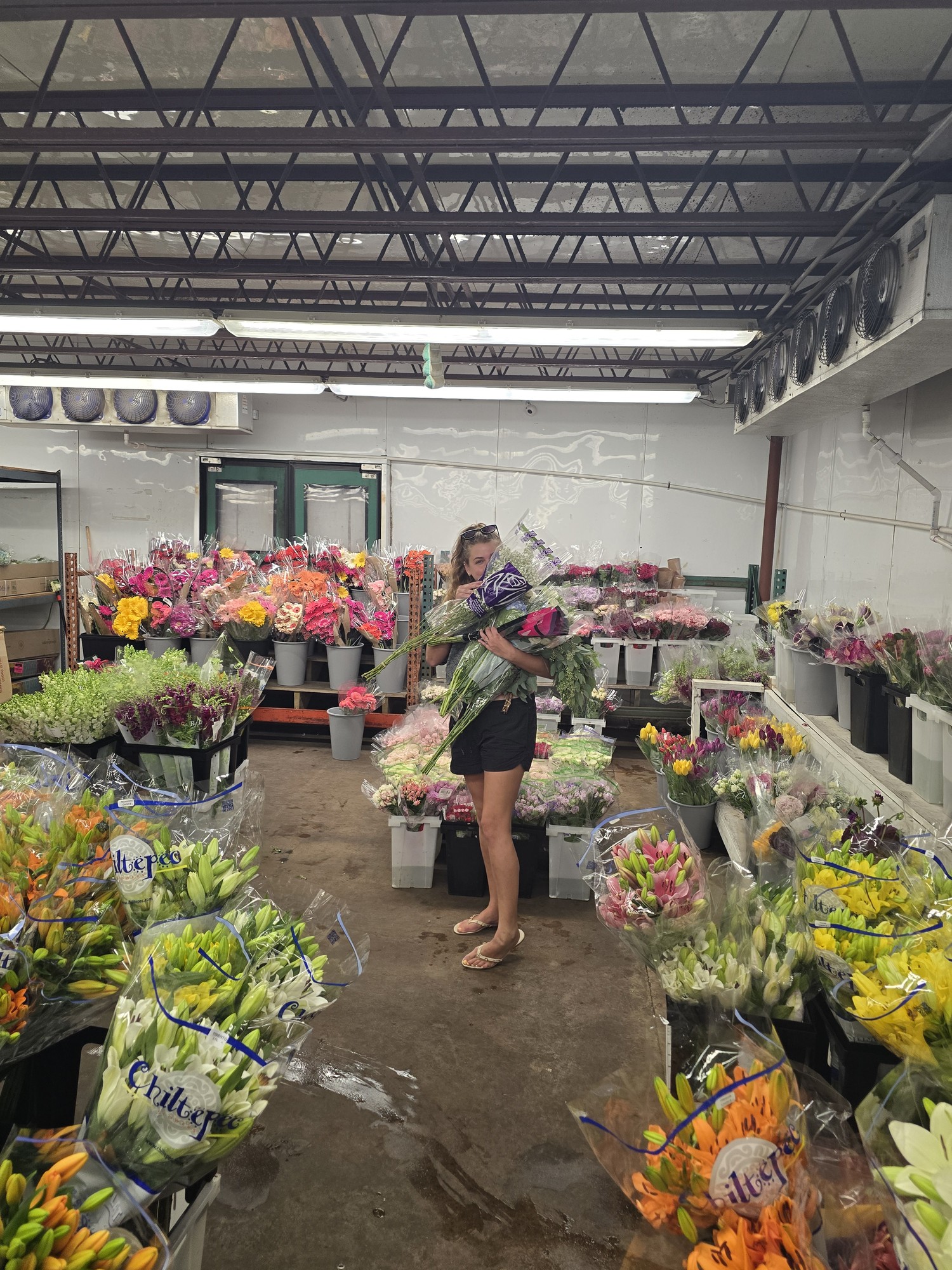 Houston florist Lola hand-selecting fresh white lisianthus and roses at the Houston wholesale flower market each morning
